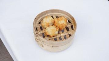 Fried Dumpling in Bamboo Basket on white background. photo