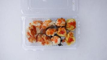 Sushi en el plastico caja en el blanco antecedentes. parte superior vista. foto