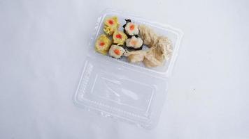 Steamed dumplings in a plastic box on white background. photo