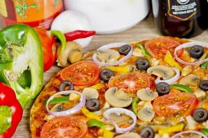 Popular colorful ingredients as like tomatoes, cheese, mushroom, capsicum, olives and other ingredients baked healthy Pizza. photo