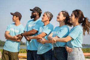 Happy Group of volunteer holding hand On beach. Protection Of Environment And Nature, Ecology Concept. photo