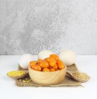 Thai sweet dessert - Mung bean paste formed in egg yolk and sugar and ingredient hulled split mung beans, egg and sugar on white background photo