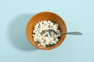 Medication with a spoon. Plate with medicines on a blue background. photo