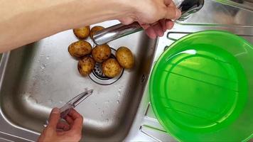 limpeza batatas com seu mãos dentro a cozinha Pia video