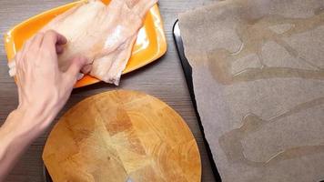 A man cuts fish on a cutting Board with a sharp kitchen knife. The view from the top. video