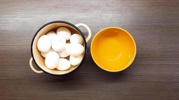 Men's hands clean boiled eggs in an orange bowl. The view from the top. video