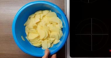 Technique of slicing potatoes on a wooden Board, top view. video