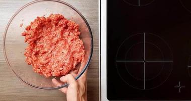 Raw ground beef is mixed with spices, onions and eggs. the view from the top. video