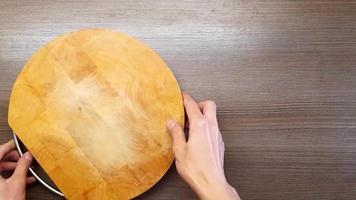 masculino mãos colocar uma corte quadro, batatas e uma cozinha faca em a mesa. a Visão a partir de a topo. video