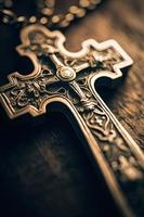 Close-up of a silver cross on a wooden table, shallow depth of field photo