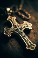 Close-up of a silver cross on a wooden table, shallow depth of field photo