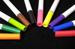 Colorful markers on black background photo