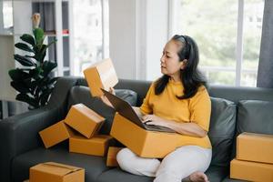 Senior business owner woman prepare parcel box and standing check online orders for deliver to customer on tablet, laptop Shopping Online concept. photo