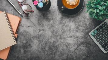 Modern office desk workplace with calculator, notebook, eyeglass, pen and cup of coffee, Top view flat lay with copy space. photo