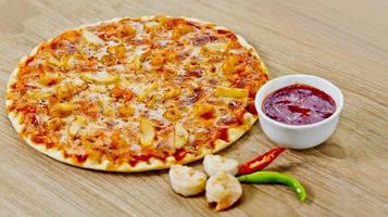 Classic Seafood Pizza with spicy chilli sauce. photo