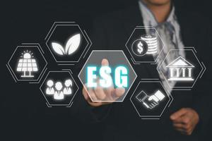 ESG environment social governance investment business concept, Businesswoman hand touching ESG icon on screen display, social and corporate governance concept photo
