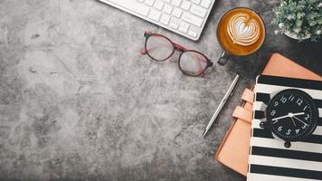 Office desk workplace with keyboard, eyeglass, pen, notebook and cup of coffee, Top view flat lay with copy space. photo