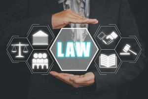 Justice and law concept, Business person hand holding law icon on virtual screen. photo