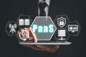 PaaS - Platform as a service, Businessman working on digital tablet with PaaS icon on VR screen on desk background, Internet technology and development concept. photo
