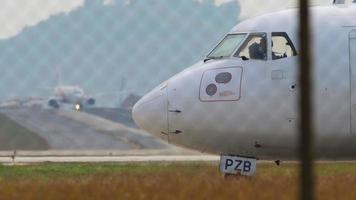 PHUKET, THAILAND JANUARY 30, 2023 - ATR 72 of Bangkok Airways taxiing at Phuket Airport. Aircraft taxiing from right to left, window view, passenger silhouettes inside. Tourism travel concept video