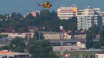 SOCHI, RUSSIA JULY 31, 2022 - Yellow helicopter flying in the blue sky, slow motion. Mil Mi 8 of Art Avia flies at Sochi airport. video