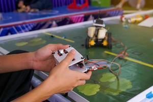 asiático alto colegio estudiantes práctica Moviente robots en el jugando campo a realizar misiones según a el reglas de el robot competencia. suave y selectivo enfocar. foto