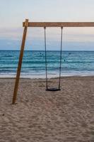 calm beach evening landscape with empty swing photo