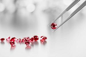 Ruby crystal diamond and tweezers on a black background with objects soft focusing 3d rendering photo