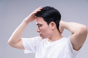 Image of young Asian man hair care on background photo