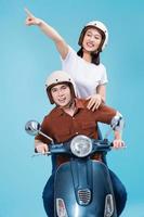 Young Asian couple ride scooter on background photo