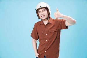 joven asiático hombre vistiendo casco en antecedentes foto