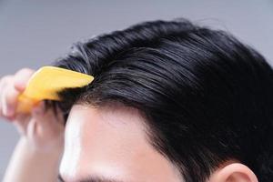 Image of young Asian man hair care on background photo