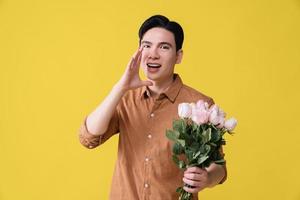 Young Asian man holding flower on background photo