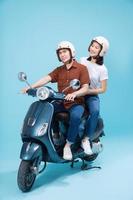 Young Asian couple ride scooter on background photo