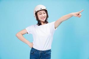 Young Asian woman wearing helmet on background photo