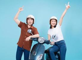 Young Asian couple ride scooter on background photo