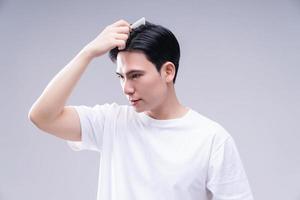 Image of young Asian man hair care on background photo