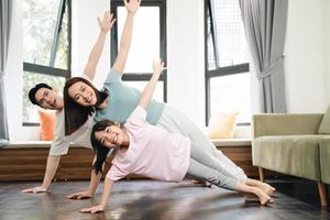 Young Asian family exercise at home photo