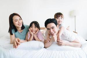 Young Asian family on bed photo