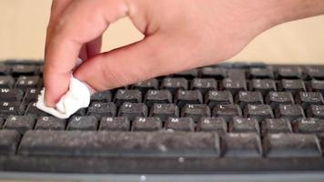 Fingers cleaning taking care of computer keyboard, disinfect keyboard, using disinfectant, selective focus, noise effect video