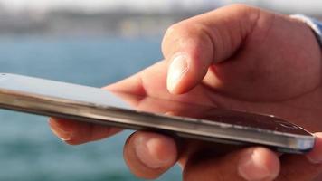 Smartphone user and sea view, on seaside, bosphorus, selective focus, noise effect video