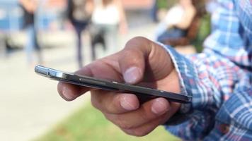 person använda sig av smartphone och Sammanträde med en se, hav se, bro, i en solig dag, selektiv fokus, ljud effekt video