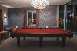 Chandelier over red snooker table in luxury hotel photo