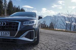 Car parked on road with mountain range in winter photo