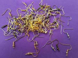 A lot of laid out schwenz hooks on a purple background Earring accessory Materials for creating jewelry photo