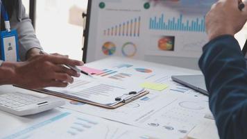Financial analysts analyze business financial reports on a digital tablet planning investment project during a discussion at a meeting of corporate showing the results of their successful teamwork. video