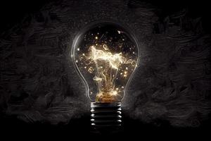 Sparkling light bulb on black background with ample copy space photo