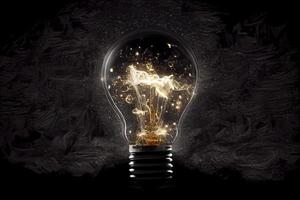 Sparkling light bulb on black background with ample copy space photo