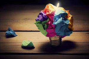 great idea concept with crumpled colorful paper and light bulb on wooden table photo