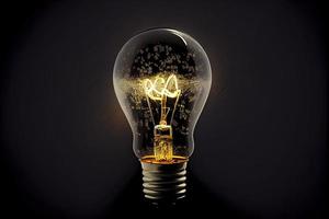 Sparkling light bulb on black background with ample copy space photo